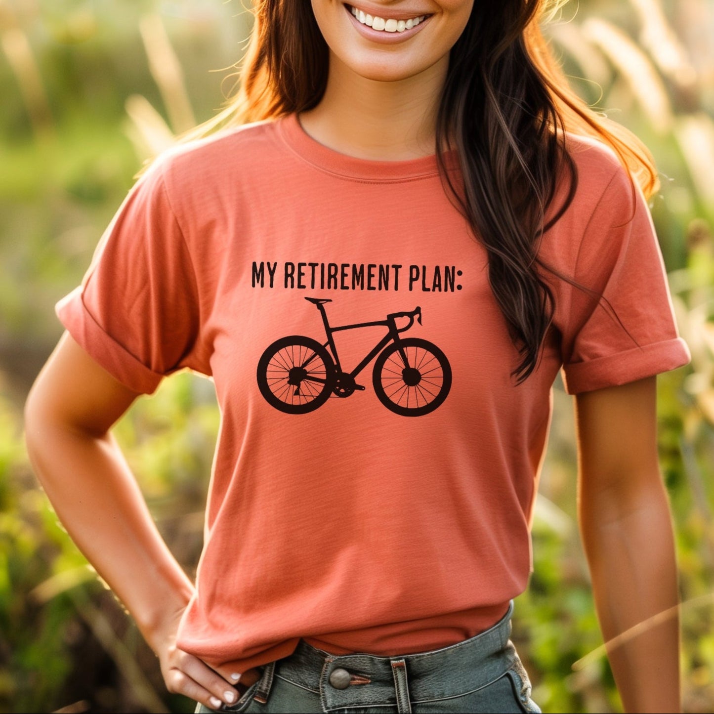 Woman wearing a t-shirt with 'My retirement plan: bike' text in a natural setting