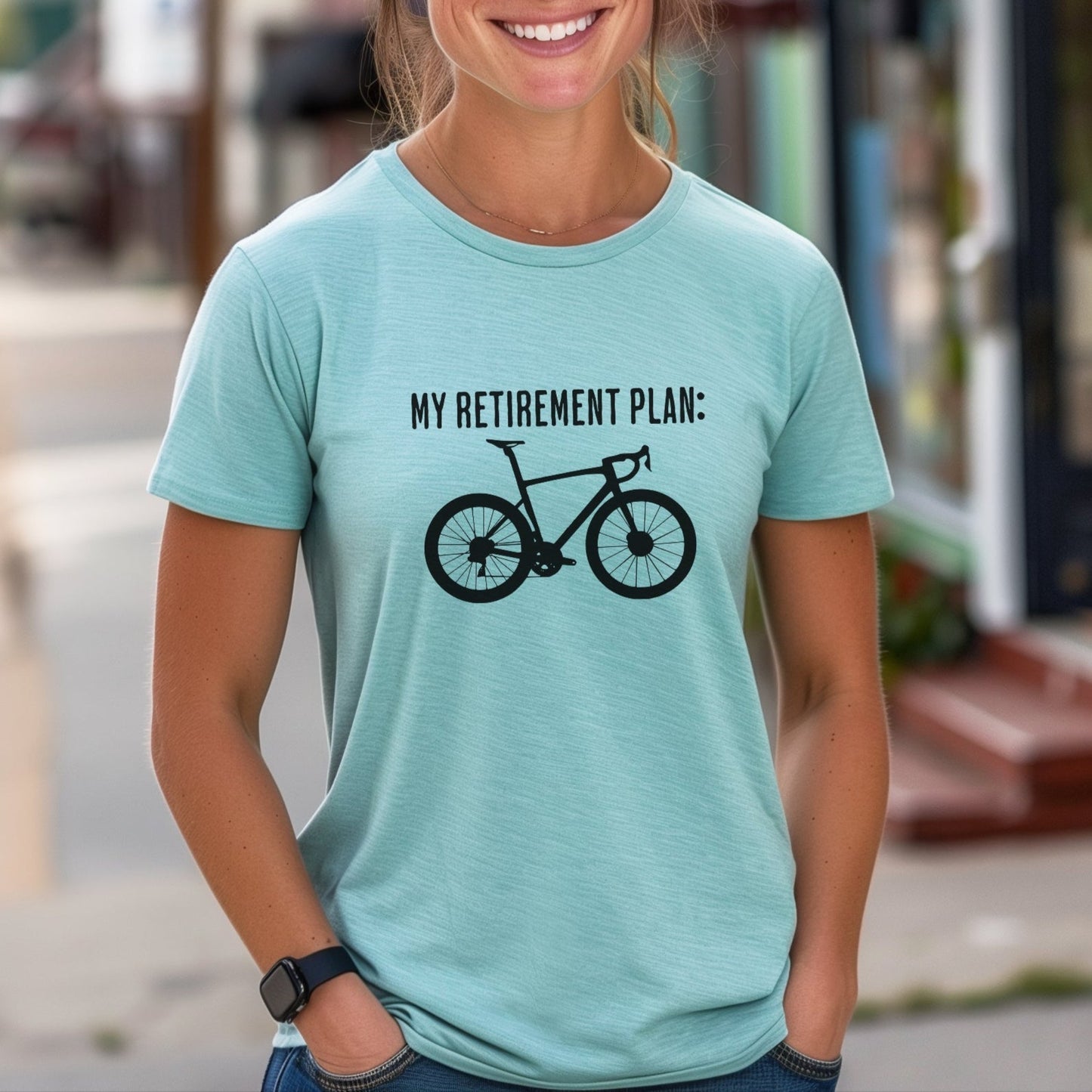 Woman wearing a light blue t-shirt with a bicycle graphic and text on a city street.
