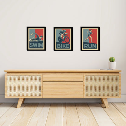 Wooden sideboard with framed posters labeled 'Swim', 'Bike', and 'Run' on a light gray wall.