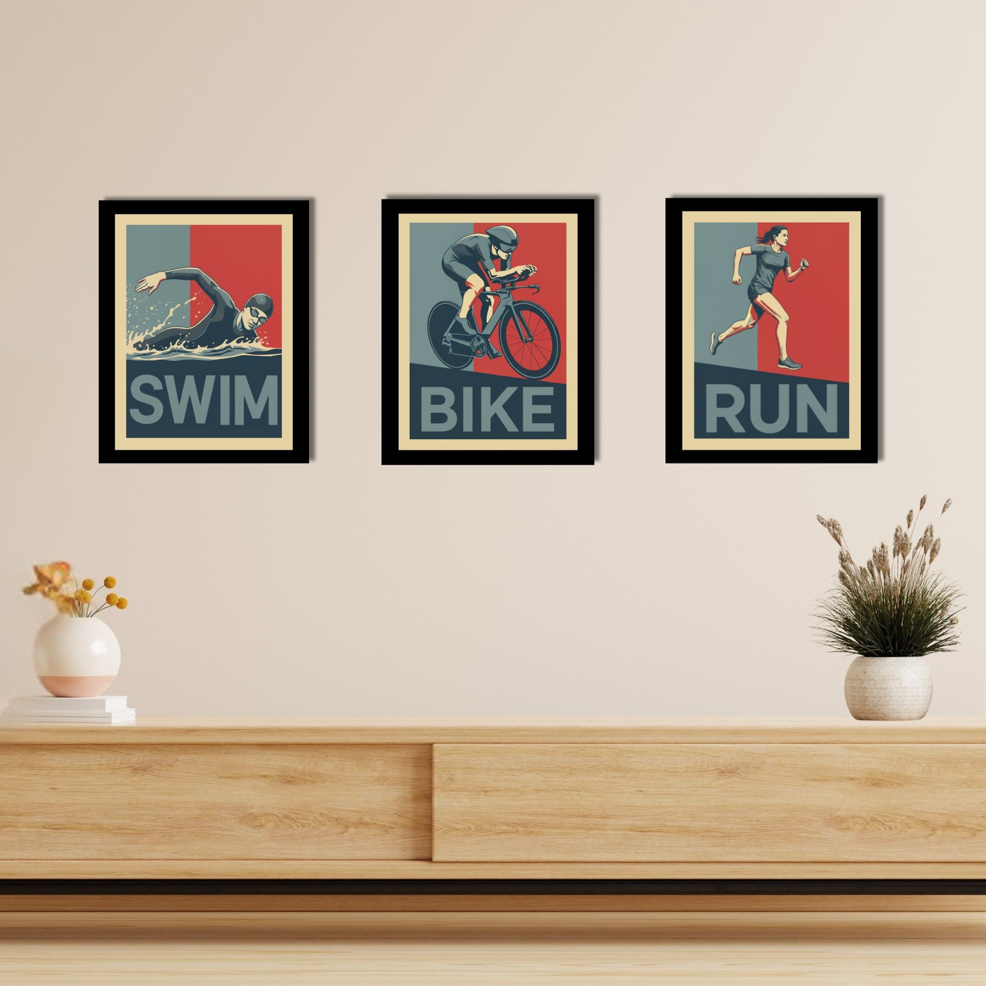 Three framed posters of swimmer, cyclist, and runner on a wall above a wooden shelf.