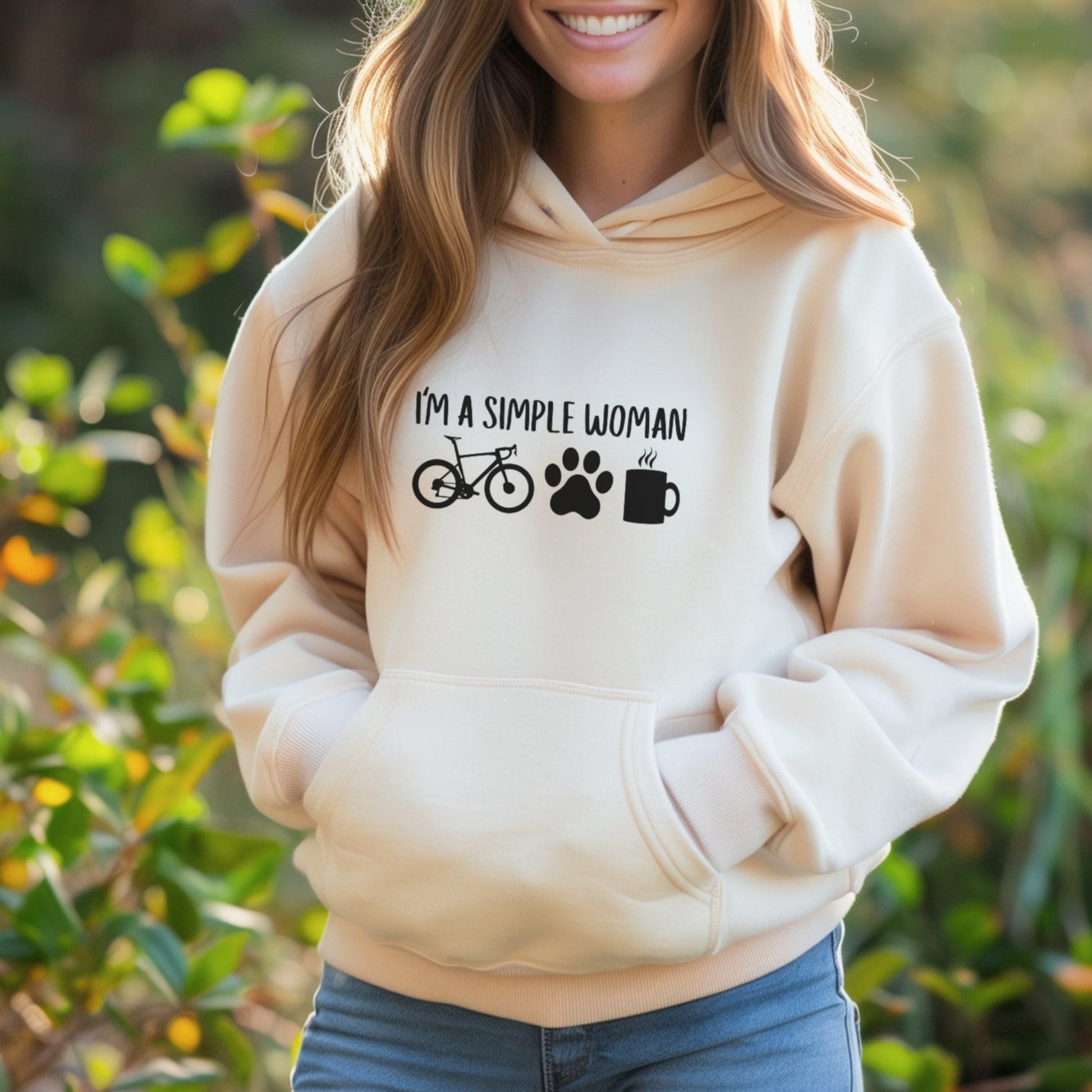 Woman wearing a beige hoodie with text and symbols outdoors