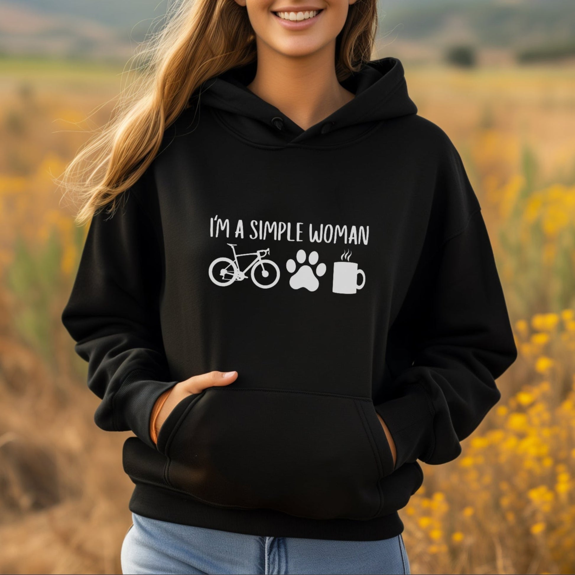 Woman wearing a black hoodie with text and symbols in a field
