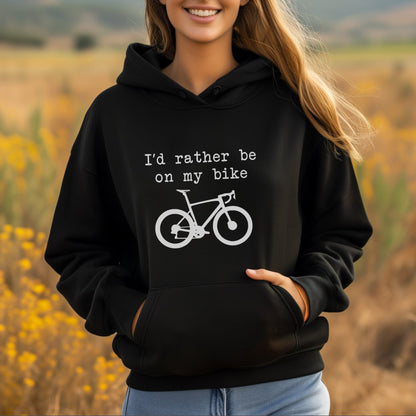 Woman wearing a black hoodie with a bicycle graphic and text in a field