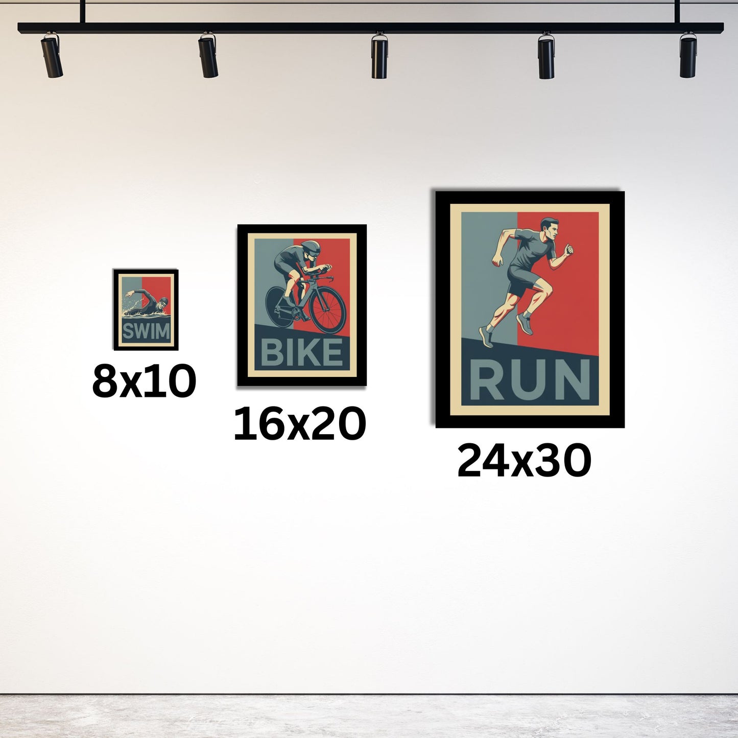 Three framed posters of a swimmer, cyclist, and runner with size labels on a white wall.